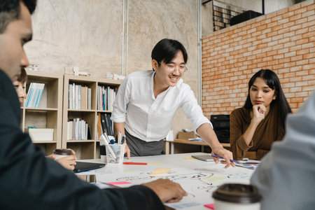 Multiracial group of young creative people in smart casual wear discussing business brainstorming meeting ideas mobile application software design project in modern office. Coworker teamwork concept.の写真素材