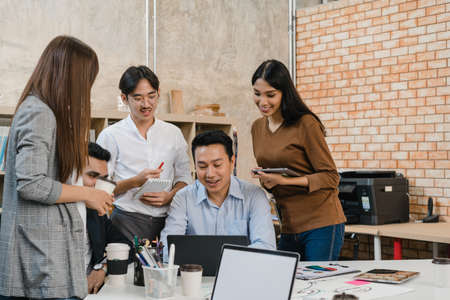 Multiracial group of young creative people in smart casual wear discussing business brainstorming meeting ideas mobile application software design project in modern office. Coworker teamwork concept.の写真素材