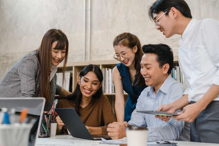 Multiracial group of young creative people in casual wear meeting brainstorming ideas about new paperwork project colleagues working together planning success strategy enjoy teamwork in small officeの写真素材