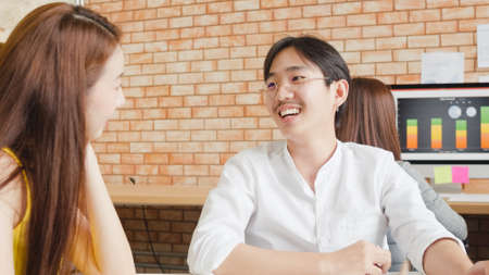 Multiracial group of young creative people in casual wear meeting brainstorming ideas about new paperwork project colleagues working together planning success strategy enjoy teamwork in small officeの写真素材