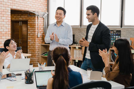 Multiracial group of young creative people in smart casual wear discussing business brainstorming meeting ideas mobile application software design project in modern office. Coworker teamwork concept.の写真素材