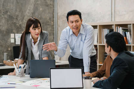 Multiracial group of young creative people in smart casual wear discussing business brainstorming meeting ideas mobile application software design project in modern office. Coworker teamwork concept.の写真素材