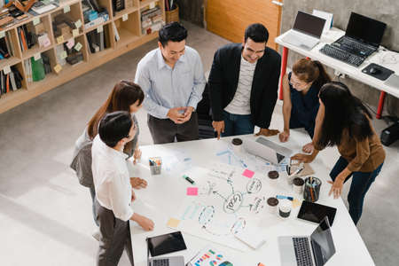 Multiracial group of young creative people in smart casual wear discussing business brainstorming meeting ideas mobile application software design project in modern office. Coworker teamwork concept.の写真素材