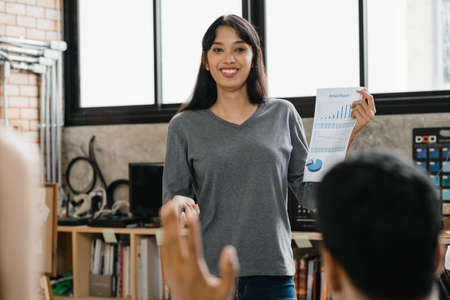 Multiracial group of young creative people in casual wear meeting brainstorming ideas about new paperwork project colleagues working together planning success strategy enjoy teamwork in small officeの写真素材