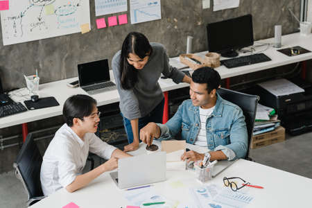 Multiracial group of young creative people in smart casual wear discussing business brainstorming meeting ideas mobile application software design project in modern office. Coworker teamwork concept.の写真素材