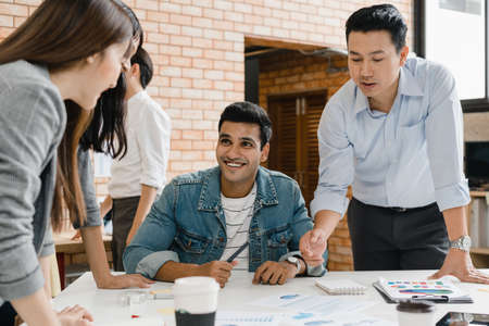 Multiracial group of young creative people in smart casual wear discussing business brainstorming meeting ideas mobile application software design project in modern office. Coworker teamwork concept.の写真素材