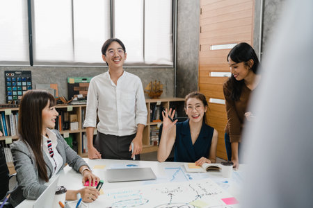 Multiracial group of young creative people in casual wear meeting brainstorming ideas about new paperwork project colleagues working together planning success strategy enjoy teamwork in small officeの写真素材
