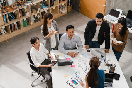 Multiracial group of young creative people in smart casual wear discussing business brainstorming meeting ideas mobile application software design project in modern office. Coworker teamwork concept.の写真素材