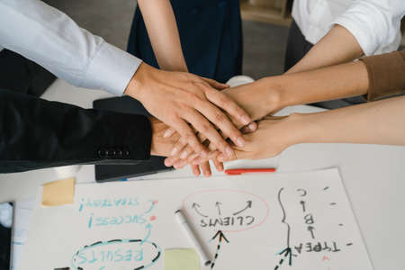 Multiracial group of young creative people in casual wear meeting brainstorming ideas about new paperwork project colleagues working together planning success strategy enjoy teamwork in small officeの写真素材