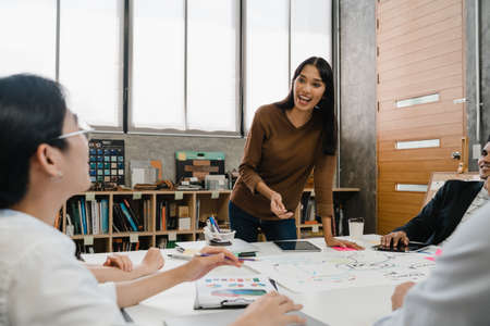 Multiracial group of young creative people in smart casual wear discussing business brainstorming meeting ideas mobile application software design project in modern office. Coworker teamwork concept.の写真素材