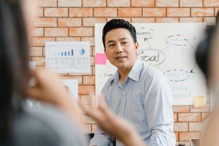 Multiracial group of young creative people in smart casual wear discussing business brainstorming meeting ideas mobile application software design project in modern office. Coworker teamwork concept.の写真素材