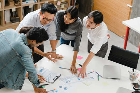 Multiracial group of young creative people in smart casual wear discussing business brainstorming meeting ideas mobile application software design project in modern office. Coworker teamwork concept.の写真素材