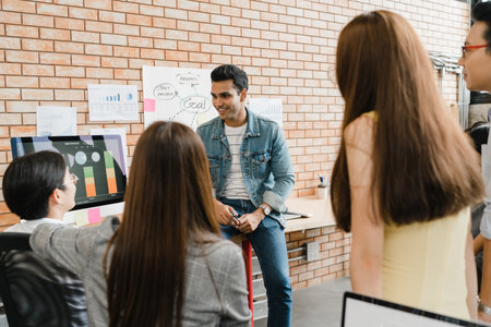 Multiracial group of young creative people in casual wear meeting brainstorming ideas about new paperwork project colleagues working together planning success strategy enjoy teamwork in small officeの写真素材