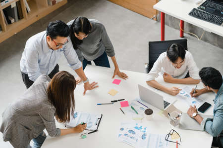 Multiracial group of young creative people in smart casual wear discussing business brainstorming meeting ideas mobile application software design project in modern office. Coworker teamwork concept.の写真素材