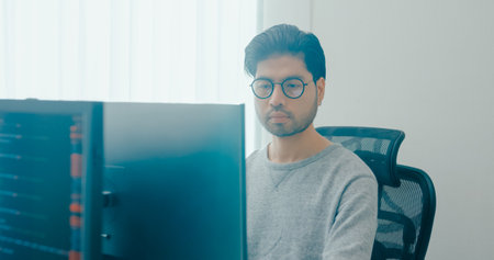Young adult Asia male freelance eyeglasses typing write prompt AI bot IT app smart program nomad, video game, terminal with coding, user interface, designer, big data center on desktop computer.の写真素材