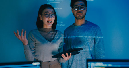 Group adult Asia male female software developers mentor leader manager talk strategy plan to executive write prompt AI bot IT app program nomad, video game, data center. Projecting slideshow code.の写真素材