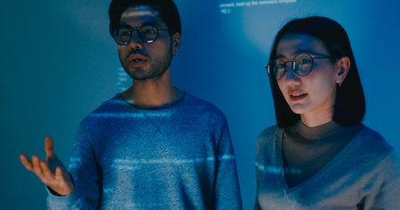 Group adult Asia male female software developers mentor leader manager talk strategy plan to executive write prompt AI bot IT app program nomad, video game, data center. Projecting slideshow code.の写真素材