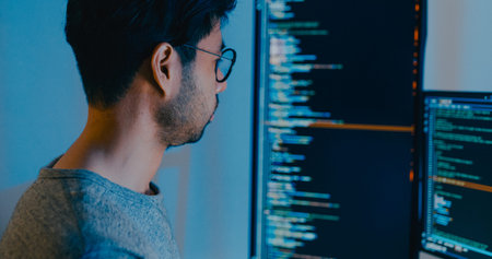 Closeup young adult Asia male freelance typing write prompt AI bot IT app smart program nomad, video game, terminal with coding language, designer, big data center on desktop computer in night office.の写真素材