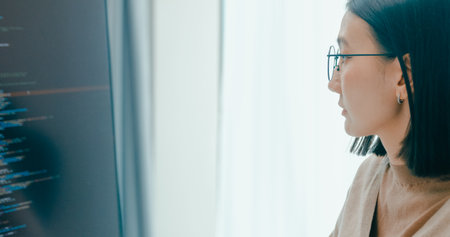 Closeup young adult Asia female freelance eyeglasses typing write prompt AI bot IT app program nomad, video game, terminal with coding, user interface, designer, big data center on desktop computer.の写真素材