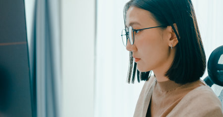 Closeup young adult Asia female freelance eyeglasses typing write prompt AI bot IT app program nomad, video game, terminal with coding, user interface, designer, big data center on desktop computer.の写真素材