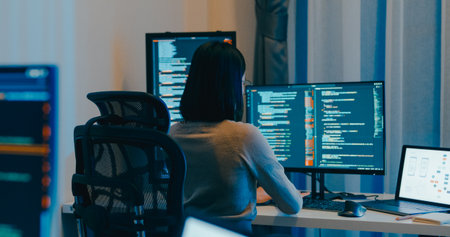 Young Asia female freelance eyeglasses typing write prompt AI bot IT app smart program nomad, video game, terminal with coding language, designer, big data center on desktop computer in night office.の写真素材
