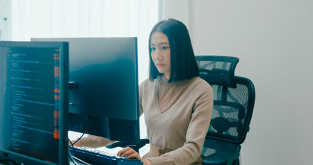 Young adult Asia female freelance typing write prompt AI bot IT app smart program nomad, video game, terminal with coding language, user interface, designer, big data center on desktop computer.の写真素材