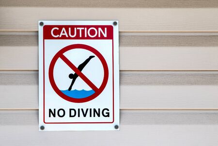 A "No Diving" Sign by a swimming pool.の写真素材