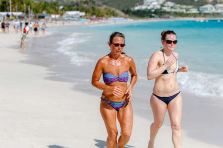 Saint Martin, French Antilles, March 22, 2017: Two women are running along a beach.のeditorial素材