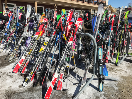 Stratton, VT, March 05, 2017: Skis and snowboards are resting on the racks near the main lodge at Stratton Mountain.のeditorial素材