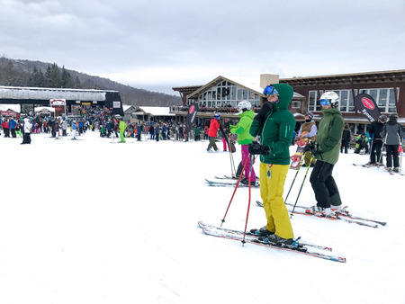 Stratton, VT, February 11, 2017: Skiers at the bottom of the slopes of Stratton mountain near the main lodge.のeditorial素材