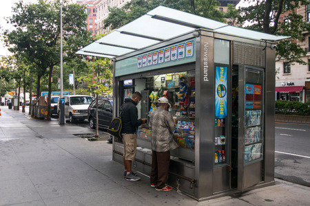 New York, September 28, 2016: Two people are making purchases at a newsstand in Manhattan's Upper West Side.のeditorial素材