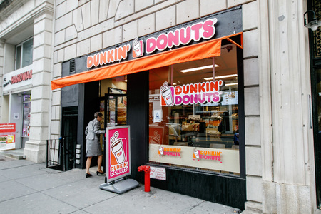 New York, January 21, 2017: A woman is walking into a Dunkin Donuts store on west 72 street in Manhattan.のeditorial素材