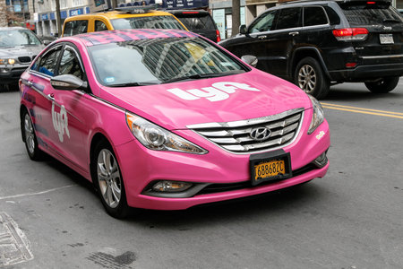 New York, March 11, 2017: A pink car with Lyft logo is driving along 14th street in Manhattan. Lyft...