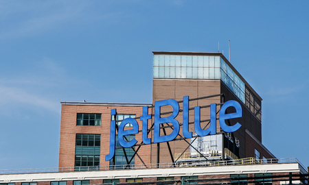 Queens, New York, August 10, 2017: jetBlue advertisement is displayed at the top of a building.のeditorial素材