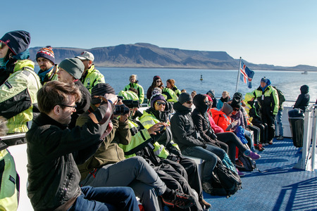 Reykjavik, Iceland, August 20, 2017: People wearing warm overalls are riding a boat during a whale watching tour on a sunny afternoon.のeditorial素材