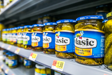 Jars of Vlasic pickle chips on the shelves of a Walmart store.のeditorial素材