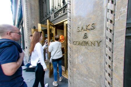 People are walking into the flagship Saks Fifth Avenue department store on Fifth Avenue in New York City.のeditorial素材