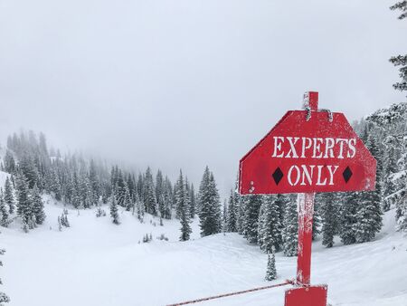 "Experts Only" sign warning skiers of difficulties ahead.の写真素材