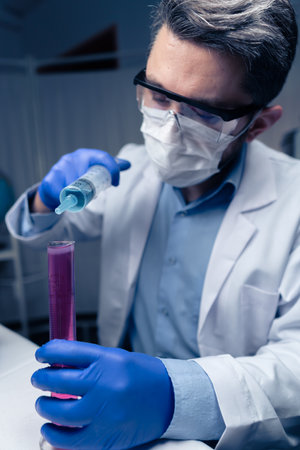 Young Scientist Checking Test Tubes In The Lab. Man Wears Protective Gogglesの写真素材