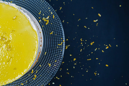 Black background, Lemon cheese cake on a glass plate. (copyspace)