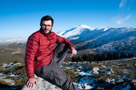 Man sitting on the edge of the mountain and enjoy the winter landscape.の写真素材