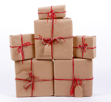 gift boxes, postal parcels wrapped in brown kraft paper tied with a red rope on a white background, isolatedの写真素材