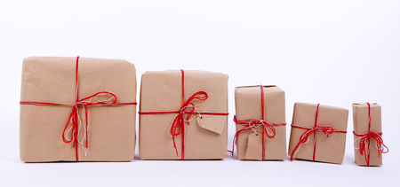 gifts in a row. packaging kraft paper, red ribbons. vintage, rustic. gifts for each family member. 5 pieces in a row.の写真素材