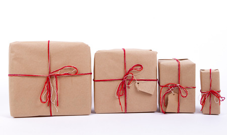 gifts in a row. kraft paper, red ribbons. vintage, rustic, the family, each according to the present. 4 giftの写真素材