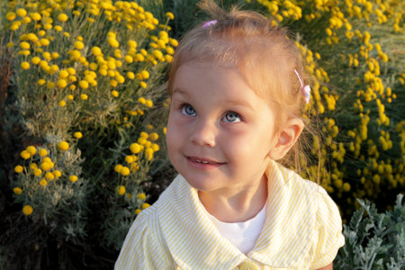 little girl with blue eyes and blond hair portrait in yellow evening sunlight toddler