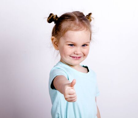 little girl in a blue t-shirt picked up the thumbs upの写真素材