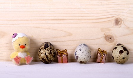quail eggs gift boxes and a toy chicken on a wooden background. Easter conceptの写真素材