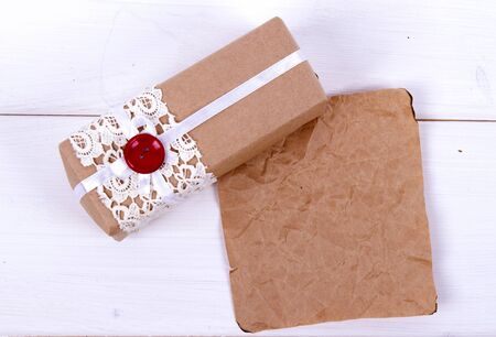 homemade gift box of kraft paper with lace and a red button and a paper peace. Gift for Valentine's day or birthday  or New Yearの写真素材
