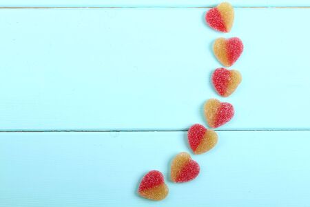 jelly hearts four pieces on turquoise on a wooden backgroundの写真素材