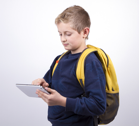 boy teenager with a backpack looking to the plate in portrait. Dressed in jeans and a blue sweater, yellow backpack, education conceptの写真素材